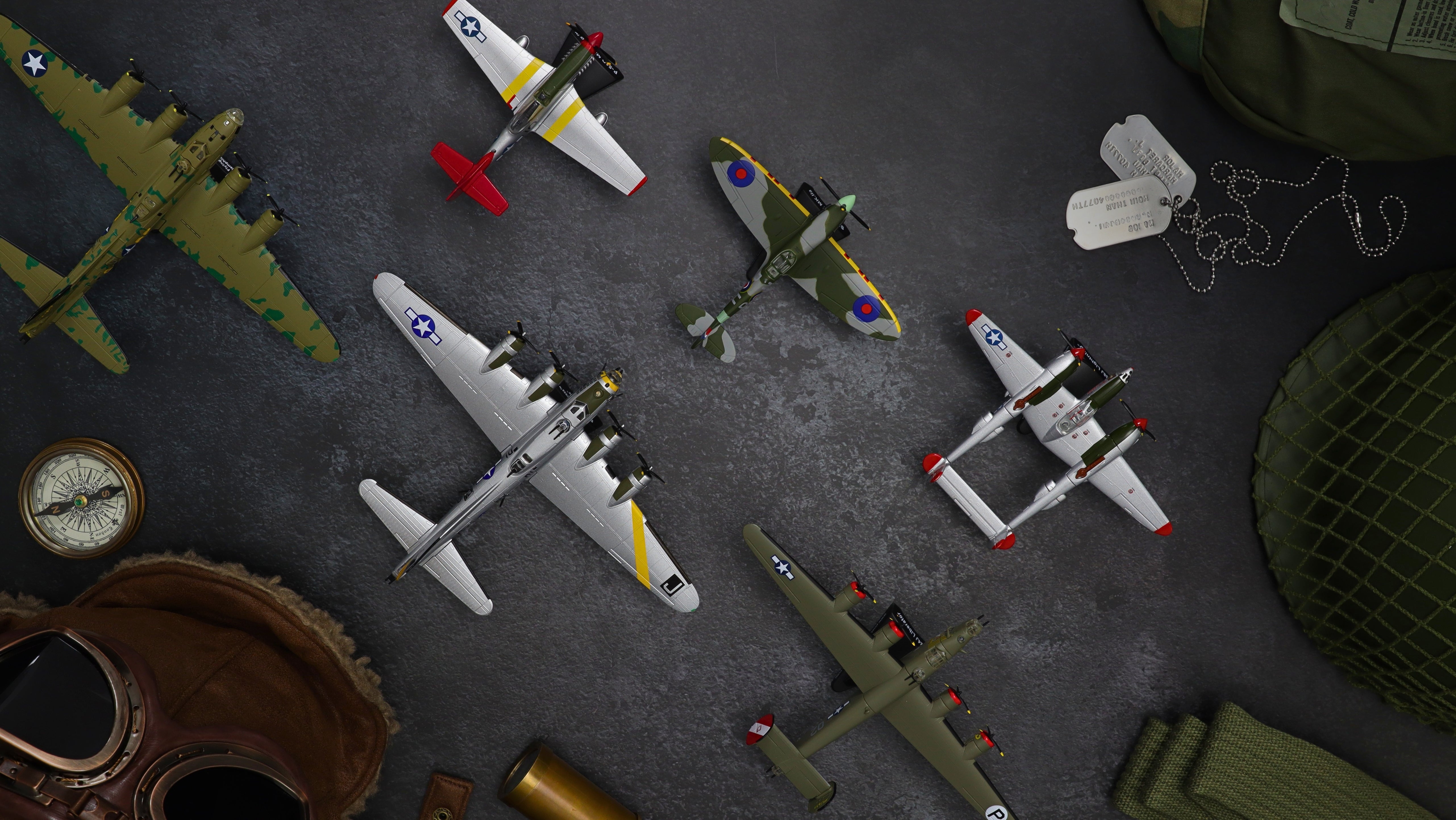 Collection of model airplanes on a textured surface with various accessories.